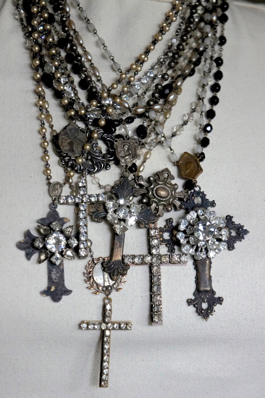 En samling antika religiösa smycken med utsmyckade kors och pärlhalsband.